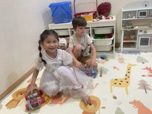 2 children playing on a mat.